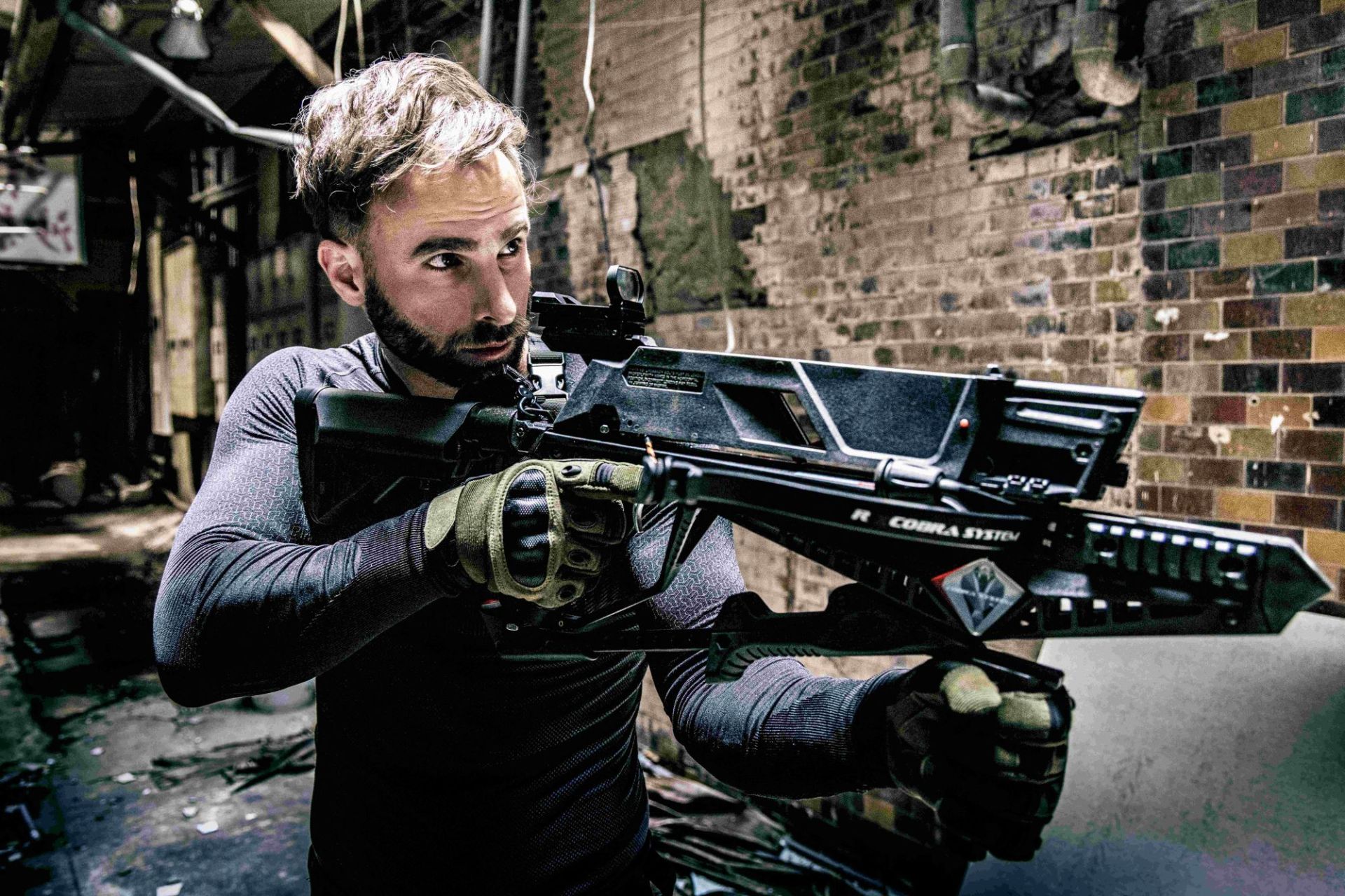 Shooter aiming a crossbow with red dot sight
